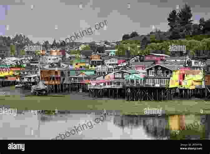 A Colorful View Of The Wooden Churches And Waterfront Houses Of Chiloe Island In Chile, Set Against The Backdrop Of Lush Green Hillsides And The Picturesque Coastline Of The Pacific Ocean. Beyond The Pampas: In Search Of Patagonia